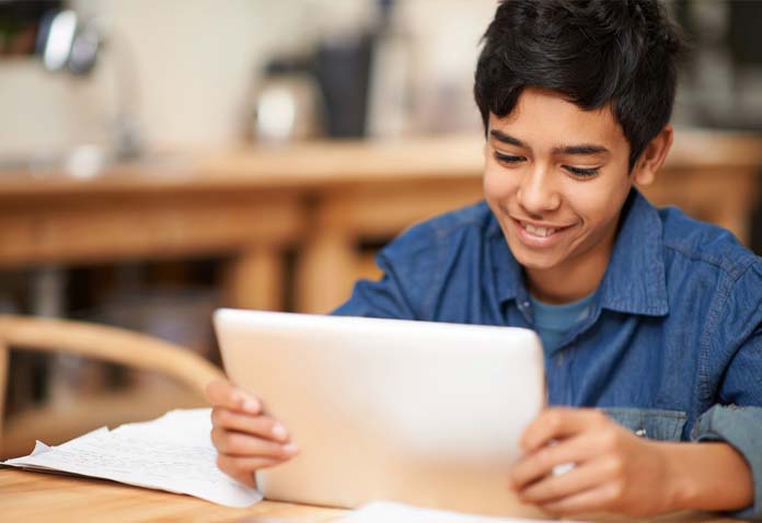 Boy smiling while using a laptop