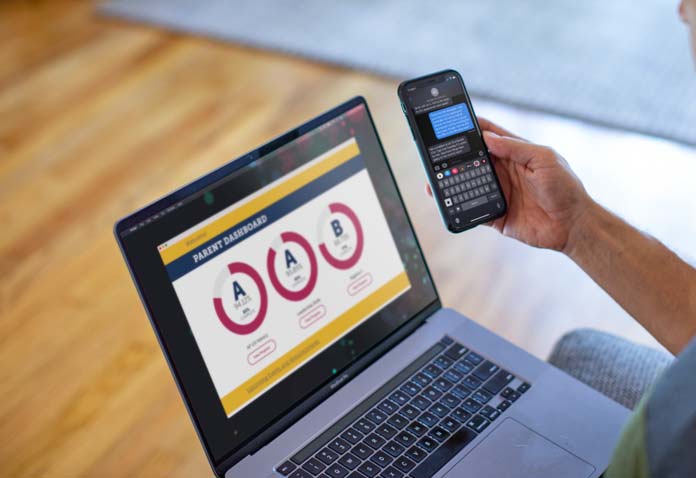 A phone being held above a laptop